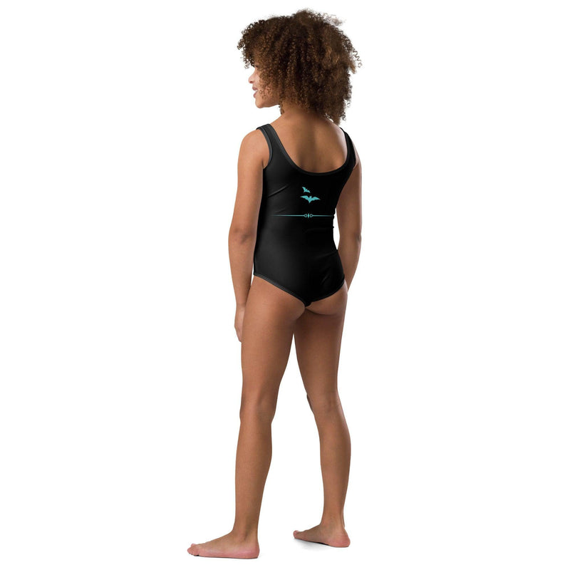 Back view of girl with curly hair wearing a black kids leotard or swimsuit with dancing ballerina ghosts