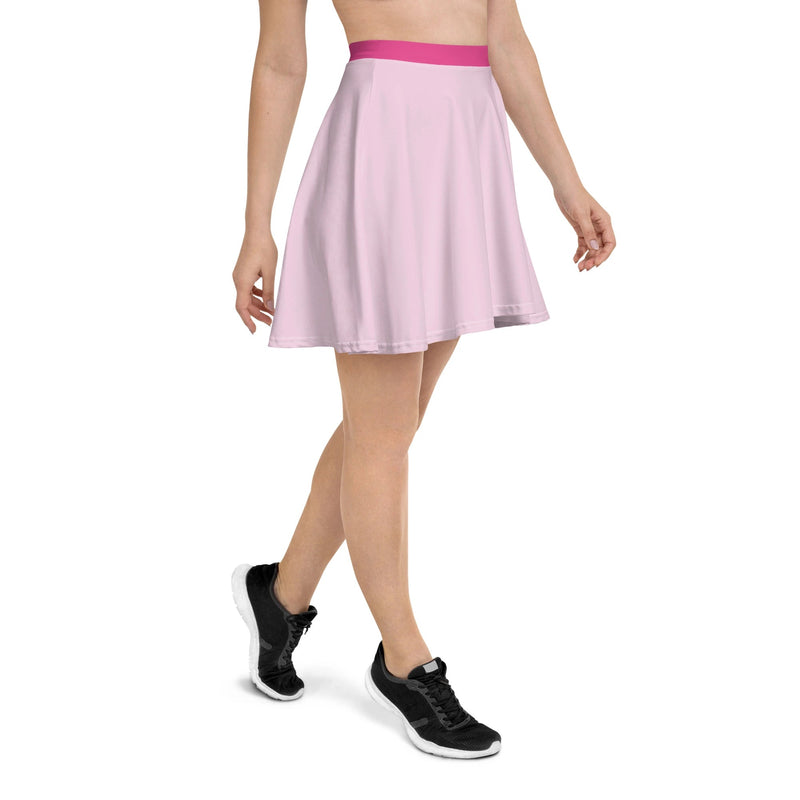 A woman wearing a flowy, pastel pink skater skirt with a Barbie pink, stretchy waistband. 